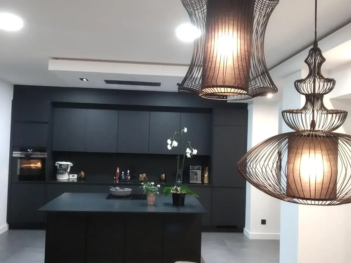 Cuisine noire avec îlot central et suspensions
