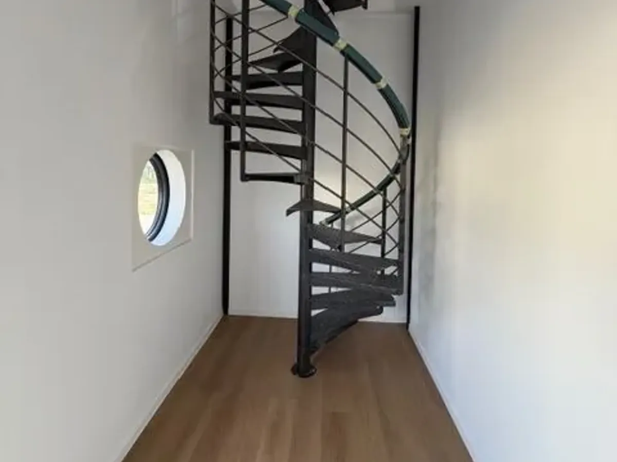 Escalier colimaçon posé dans une pièce rénovée