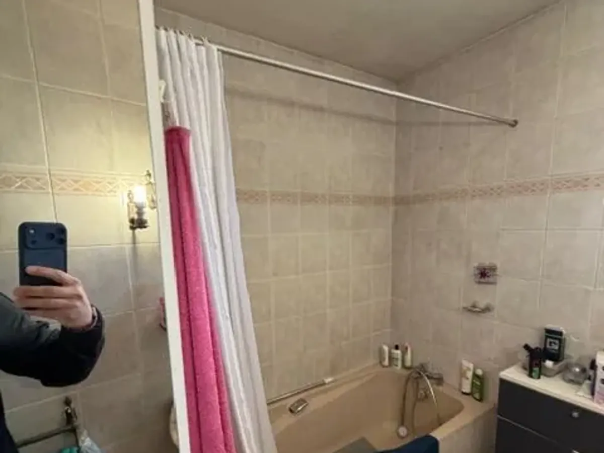 Salle de bain avant travaux : baignoire et carrelage beige d'origine